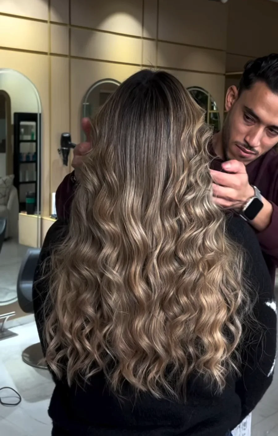 Balayage blond travaillé en boucles longues, vu de dos